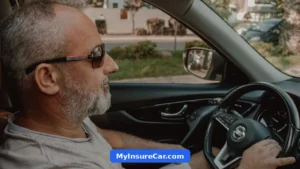 Older man with a grey beard driving his car