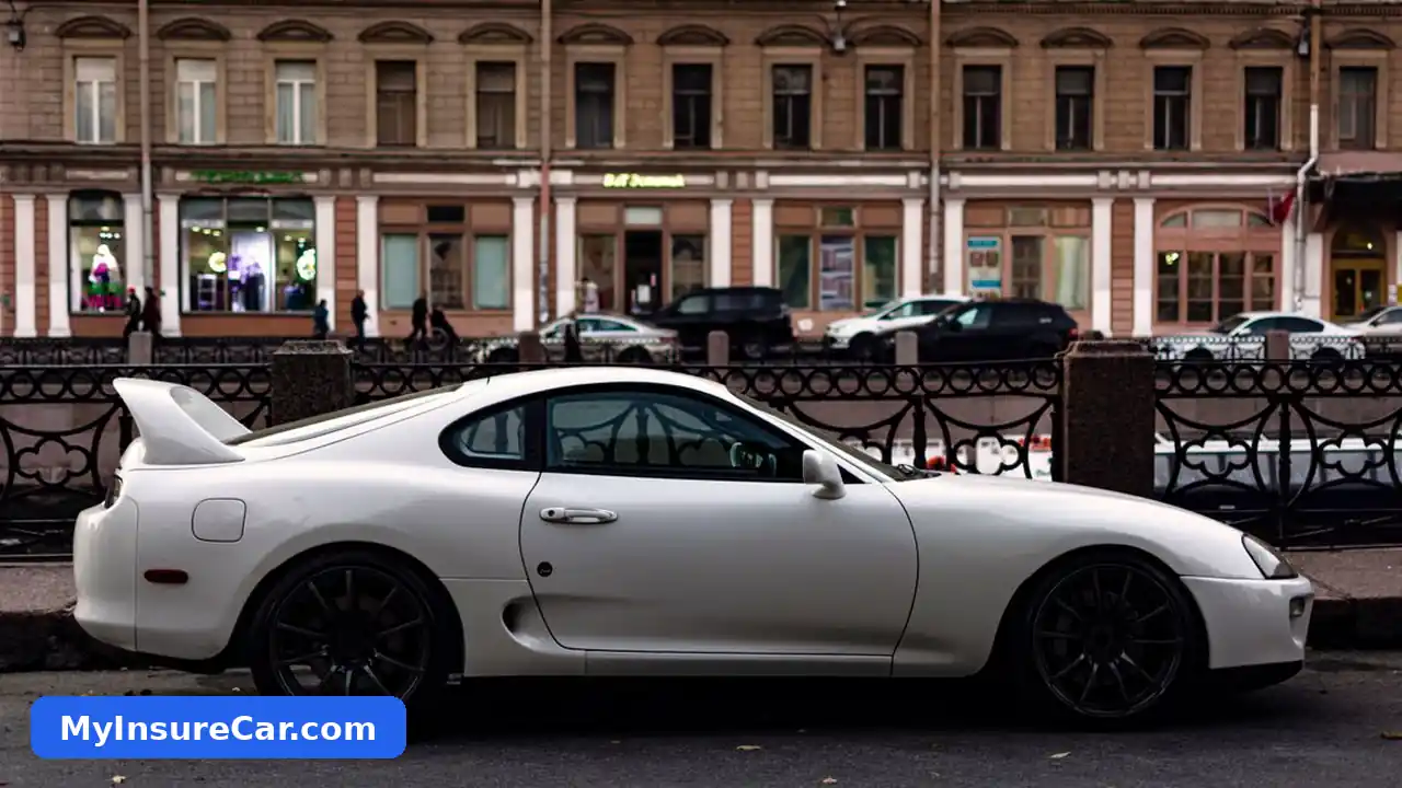 A white Toyota Supra parked on a city street with historic buildings