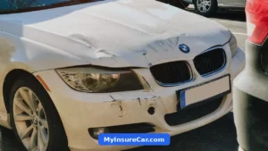 White BMW sedan with front-end damage on a city street